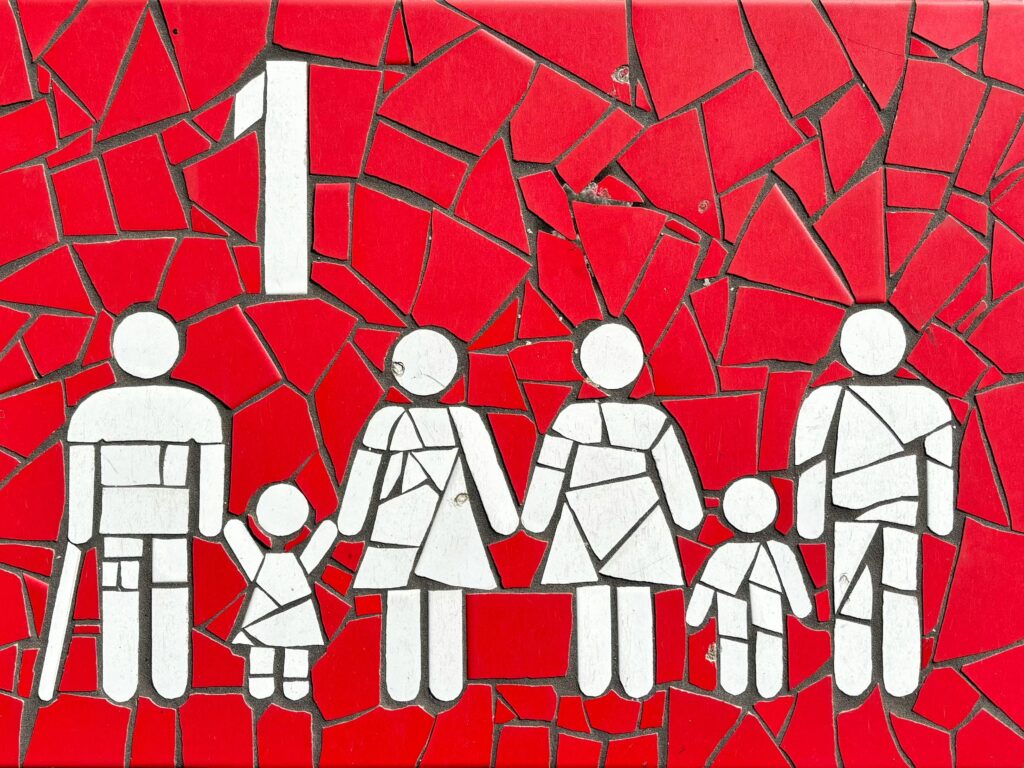 Colorful mosaic artwork depicting a family on a vibrant red backdrop, symbolizing unity and diversity.